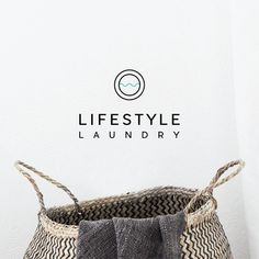 a laundry basket sitting on top of a wooden floor next to a wall with the words lifestyle laundry written above it