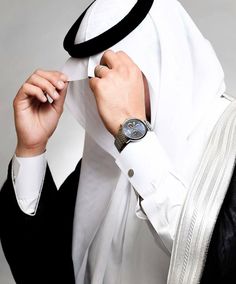 a person wearing a white and black hijab with a watch on their wrist