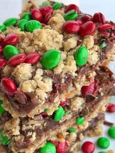 two pieces of christmas cookie bars on a plate with candy beans and milk in the background