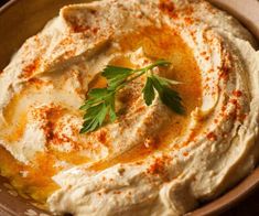 a bowl filled with hummus and topped with parsley