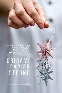 a person is holding some origami paper stars in one hand and string on the other