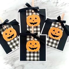 four halloween cards with pumpkins on them, tied to clothes pins and black ribbon