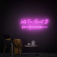 a neon sign that says let's too about it on the wall next to a table