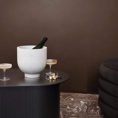 two champagne glasses sitting on top of a table next to a wine bottle and goblet