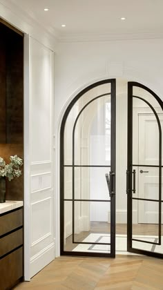 an arched glass door in a white room