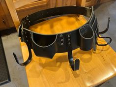 a black leather garter with metal fittings on top of a wooden table in a kitchen