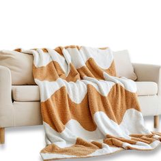 an orange and white blanket sitting on top of a couch