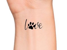 a wrist tattoo with the word love written in black ink on it's left arm