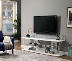 a living room with a large flat screen tv on top of a white entertainment center