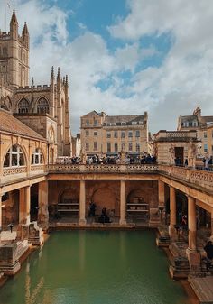 people are standing on the roof of an old building next to a pond with water in it