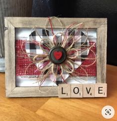 a wooden frame with a red heart on it