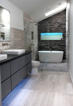 a bathroom with two sinks, a toilet and a bathtub in the middle of it