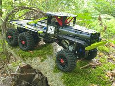 a toy truck is on top of a rock in the woods