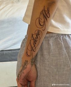 a person with a tattoo on their arm and the word love in cursive writing