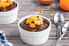 two white bowls filled with chocolate pudding and oranges