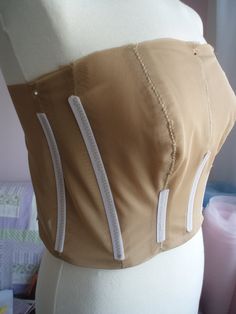 a mannequin wearing a tan top with white zippers