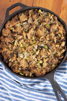 a skillet filled with stuffing sitting on top of a blue and white striped towel