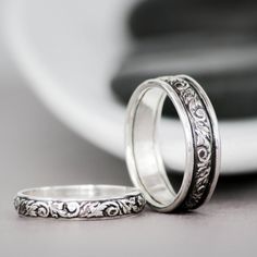 two wedding rings sitting next to each other