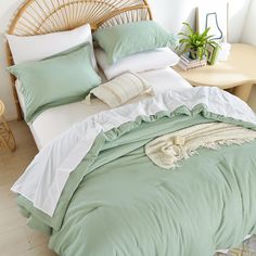 an unmade bed with green and white sheets