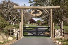 a gated entrance to a farm with a barn in the background