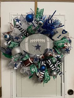 a football wreath is hanging on the front door, decorated with silver and blue ornaments