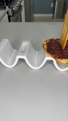 a person cutting food on top of a white plate with cheese and sauce in it