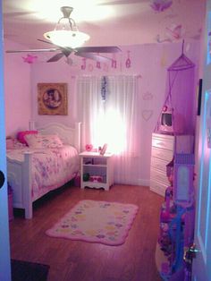 a bedroom with pink walls and white furniture