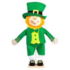 a green leprezi man standing on top of a wooden block