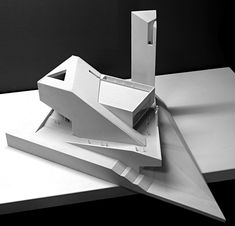 an architectural model of a building on top of a table with a black background and white backdrop