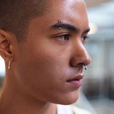 a young man with piercings on his nose