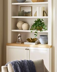 a white bookcase with books and vases on it