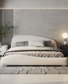 a white bed sitting on top of a wooden floor next to a nightstand and lamp