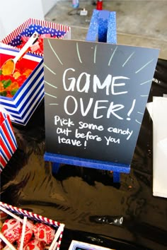 a game over sign sitting on top of a table filled with candy and candies