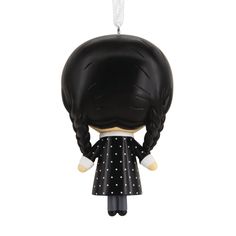 a black and white figurine hanging from a string with a ponytail on it