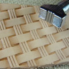 a close up of a piece of leather with a metal object on it