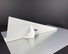 an origami sculpture is displayed on top of a white surface with a black background