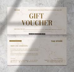 two white gift vouchers sitting on top of a marble counter next to each other