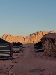 several tents in the desert with mountains in the background