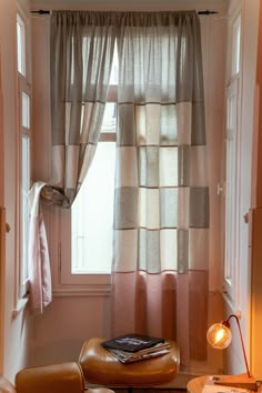 a chair and ottoman in front of a window