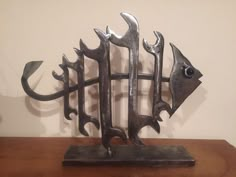 a metal fish sculpture sitting on top of a wooden table