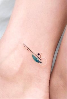 a small tattoo on the ankle of a woman's foot, with an arrow