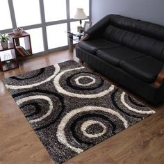 a living room with a black couch and rug