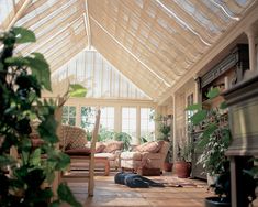 a room filled with lots of furniture and potted plants on top of wooden flooring