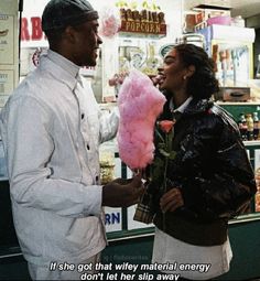 a man and woman standing in front of a store holding pink lollipops