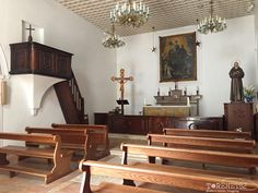 an empty church with wooden pews and chandeliers