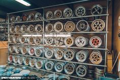 many different types of wheels on display in a shop or repair shop, including rims and tires