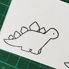 a drawing of a stencil of a dinosaur's head and tail on white paper