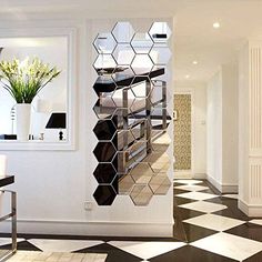 a room with black and white checkered flooring next to a wall mounted mirror