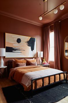 a bed sitting in a bedroom next to a large painting on the wall above it