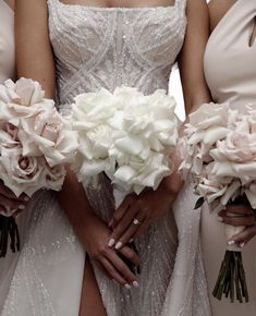 the bridesmaids are holding their bouquets together